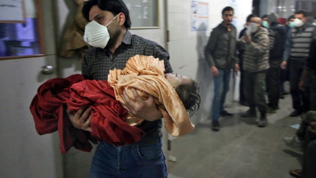 Ein syrisches Mädchen wird nach Luftschlägen des Assad-Regimes in eine Klinik im umkämpften Ost-Ghouta gebracht. (Bild: APA/AFP/AMER ALMOHIBANY)