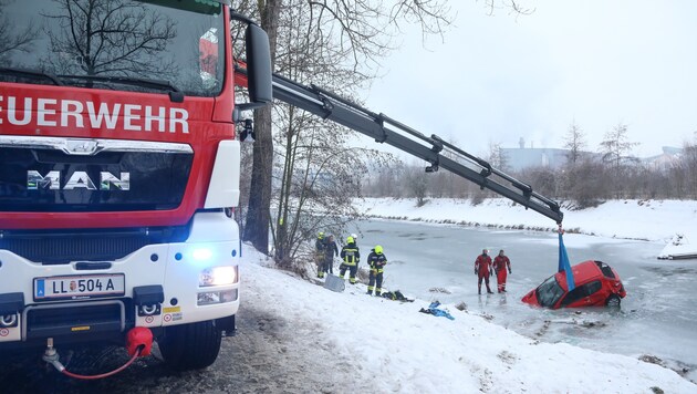 Der Feuerwehrkran barg den roten Peugeot, der beim Unfall in Ansfelden in der Krems versunken war (Bild: laumat.at)