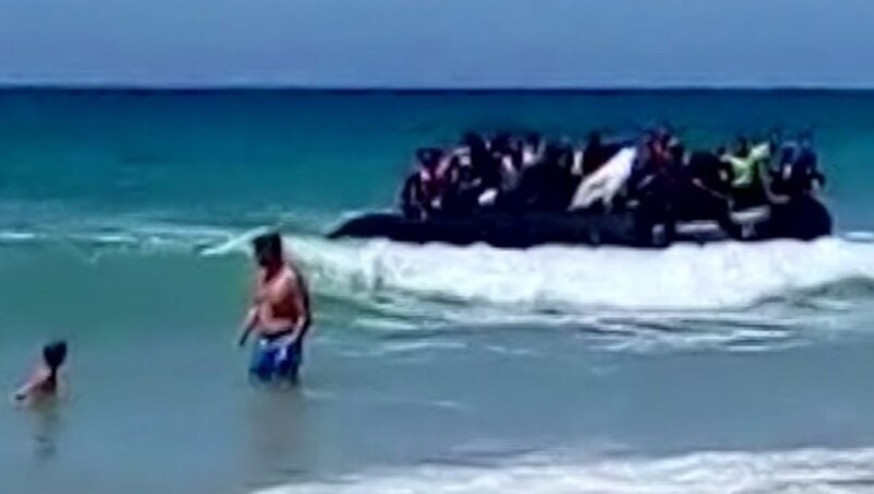 Das Flüchtlingsboot knapp vor dem spanischen Badestrand Playa de los Alemanes im Süden des Landes (Bild: AP)