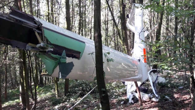 Das Segelflugzeug-Wrack mit dem eingeklemmten Piloten wurde in einem Wald am Pfenningberg entdeckt. (Bild: FOTOKERSCHI.AT/KERSCHBAUMMAYR)