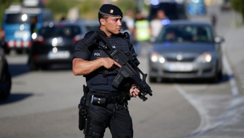 Ein schwer bewaffneter Polizist bewacht das Gelände in Subirats. (Bild: AP)