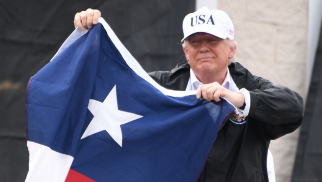 US-Präsident Trump mit der texanischen Flagge bei seinem Besuch im Katastrophengebiet (Bild: AFP)