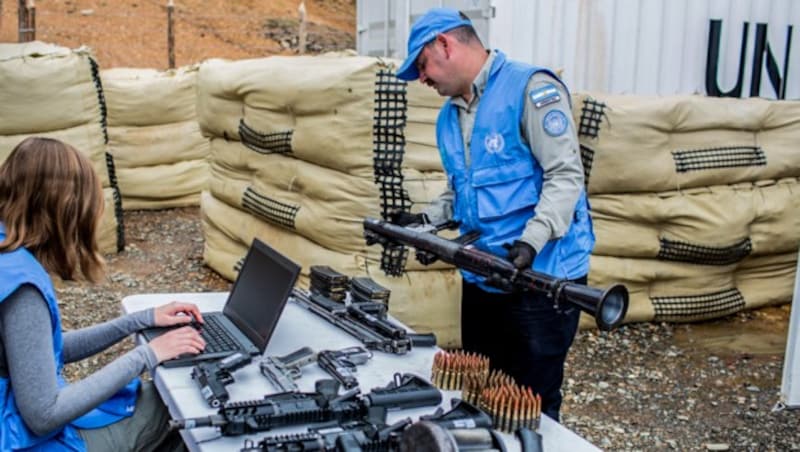 UNO-Beobachter überprüfen die von der FARC abgegebene Waffen und tragen sie in eine Liste ein. (Bild: AFP)