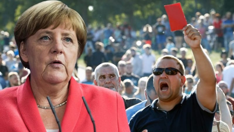 Ein wütender Demonstrant zeigt Merkel die Rote Karte. (Bild: AFP)