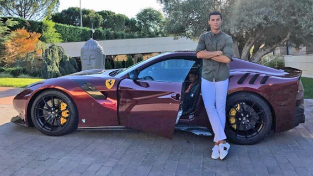 Er zeigt schon immer gerne, was er hat: Cristiano Ronaldo posiert vor seinem Ferrari. (Bild: Instagram)