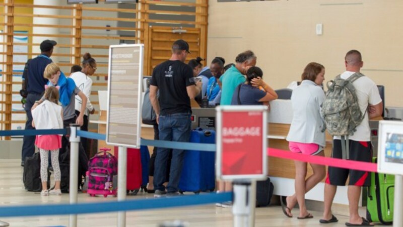 Touristen am Flughafen auf den Bahamas (Bild: AP)