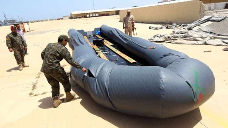 Soldaten der libyschen Küstenwache zerstören ein Schlauchboot. (Bild: AFP)