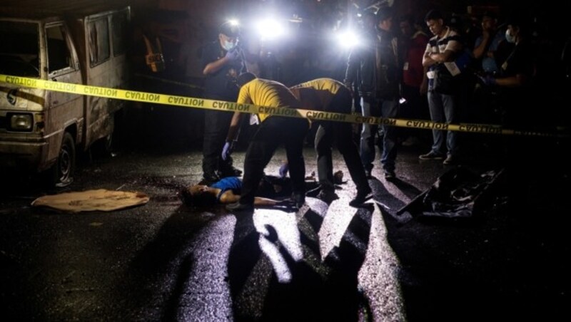 Philippinische Ermittler untersuchen die Leiche eines mutmaßlichen Drogendealers. (Bild: AFP)