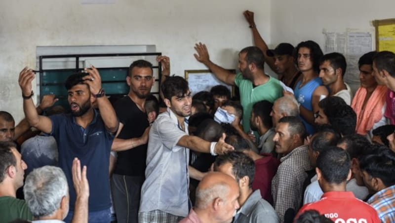 Flüchtlinge stehen am Bahnhof von Gevgelija in Mazedonien um Fahrscheine an. (Bild: APA/EPA/GEORGI LICOVSKI)