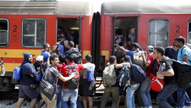 Viele Menschen versuchen, einen Platz im gerade eingefahrenen Zug zu ergattern. (Bild: AP)