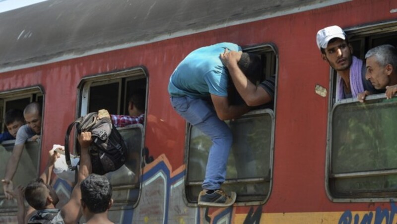Viele Menschen versuchen, einen Platz im gerade eingefahrenen Zug zu ergattern. (Bild: APA/EPA/GEORGI LICOVSKI)