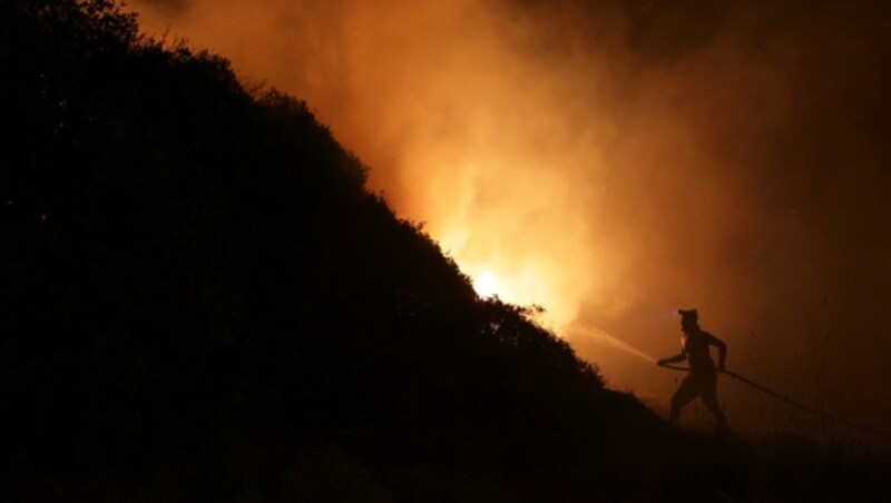 Auch in Obidos in Portugal helfen Freiwillige beim Löschen der Waldbrände. (Bild: AP)