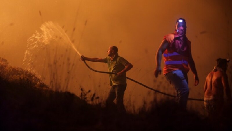 Auch in Obidos in Portugal helfen Freiwillige beim Löschen der Waldbrände. (Bild: AP)