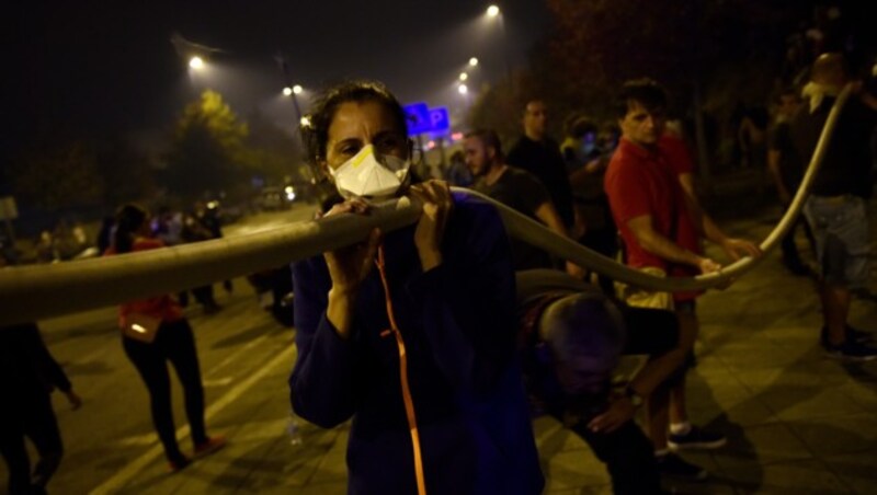 Bewohner der spanischen Stadt Vigo unterstützen mit Aufbietung aller Kräfte die Feuerwehrmänner. (Bild: AFP)