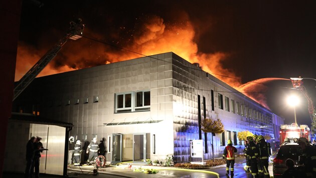 Das Feuer geriet in Traun außer Kontrolle, Flammen schlagen aus dem Hallendach. (Bild: laumat.at / Matthias Lauber)