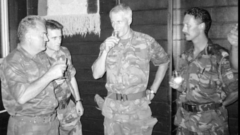 Das Bild der Schande: Mladic (links) und Thom Karremans (Bildmitte) beim Schnapstrinken (Bild: AP)