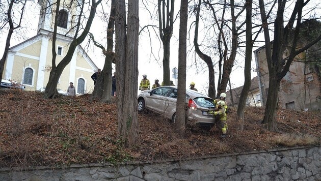 Das Auto rollte rückwärts von der Kirche über die Böschung. Blieb zum Glück an einem Baum hängen. (Bild: FF Ried im Innkreis)