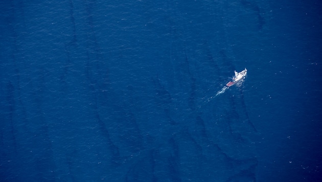 Ein Boot fährt durch den Ölteppich auf der Oberfläche des Ostchinesischen Meeres. (Bild: AP)