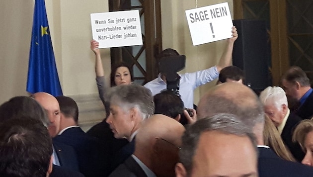 Zwei Bundesräte der Grünen hielten Schilder mit der Aufschrift "Wenn Sie jetzt ganz unverhohlen wieder Nazi-Lieder johlen" und "Sage Nein!" hoch. (Bild: APA/CHRISTIAN HABERHAUER)