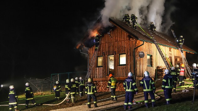 Die Feuerwehrleute mussten zur Bekämpfung des Brandes auch das Dach des Jagdhauses öffnen (Bild: laumat.at / Matthias Lauber)