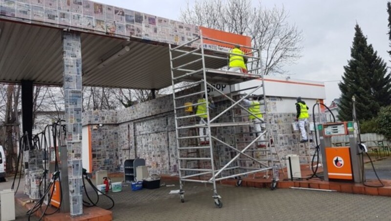 Wochenlang haben Leopold Hackl-Lehner und seine Kollegen Zeitungen gesammelt, um damit die Tankstelle zu bekleben. (Bild: Initiative "Kunst ma helfen")