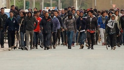 Mit Stöcken bewaffnete afrikanische Migranten in den Straßen von Calais (Bild: Associated Press)