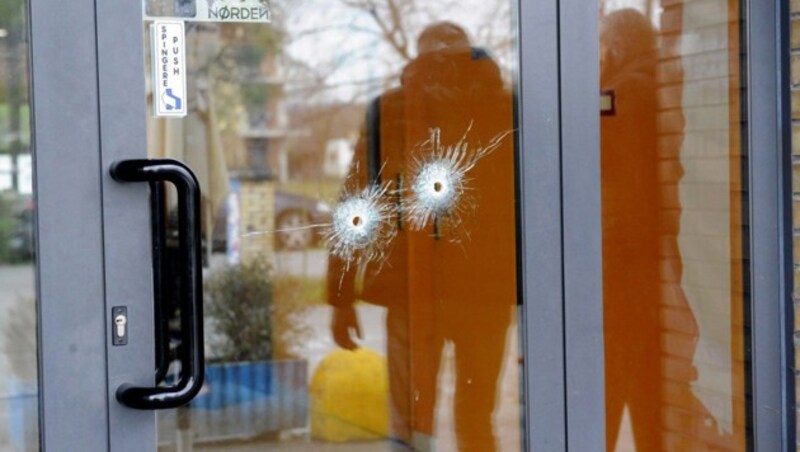 Einschlusslöcher in einer Glastür an einem der Tatorte in Macerata (Bild: AFP)