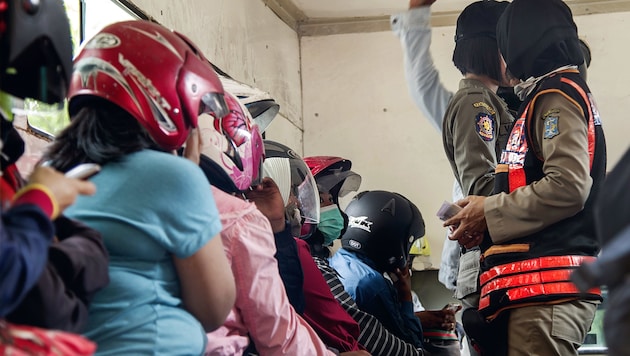 Die Paare wurden in Helmen von der Polizei abgeführt. (Bild: AFP)