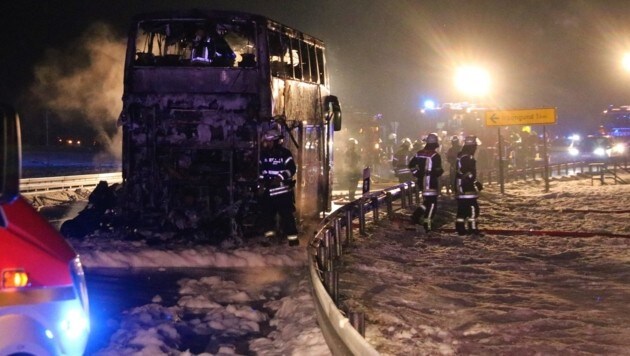 Der ausgebrannte Reisebus auf der Bundesstraße (Bild: APA/dpa/Benjamin Liss)