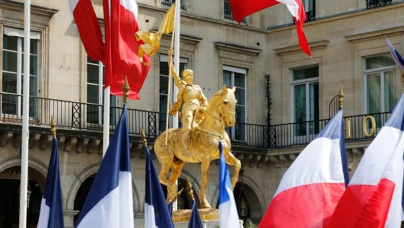 Eine Reiterstatue von Johanna von Orleans umgeben von französischen Flaggen in Paris (Bild: AFP)