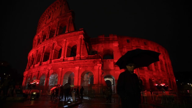 Um auf verfolgte Christen in aller Welt aufmerksam zu machen, wurde das Kolosseum in Rom am Samstagabend für etwa fünf Stunden in blutrotes Licht getaucht. (Bild: AP)
