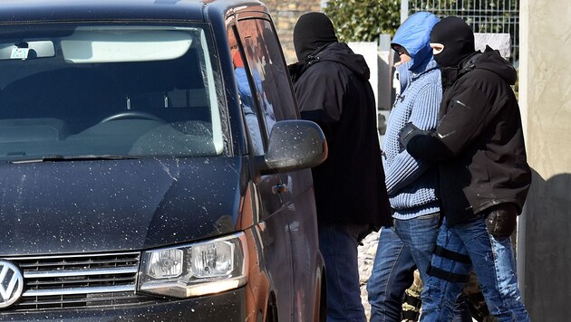 Die Polizei führt nach einer Razzia in der ostslowakischen Stadt Michalovce einen Verdächtigen ab. (Bild: AP)