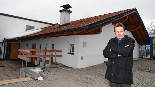 Bürgermeister Franz Schmadl zeigt, wo hinter der Volksschule das Gebäude für einen modernen Mehrzwecksaal aufgestockt werden soll (Bild: ZOOM.TIROL)