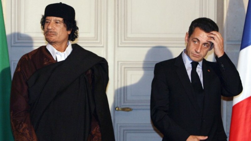 von links: Muammar al-Gaddafi, Libyens ermordetes Staatsoberhaupt, und der ehemalige französische Präsident Nicolas Sarkozy (Bild: AP)