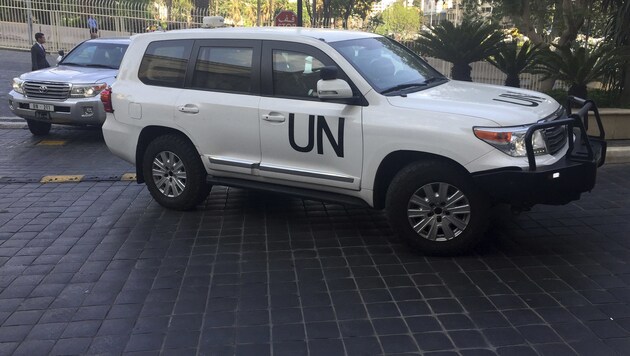 Mitglieder der OPCW in Begleitung von UN-Mitarbeitern auf dem Weg ins Hotel (Bild: ASSOCIATED PRESS)
