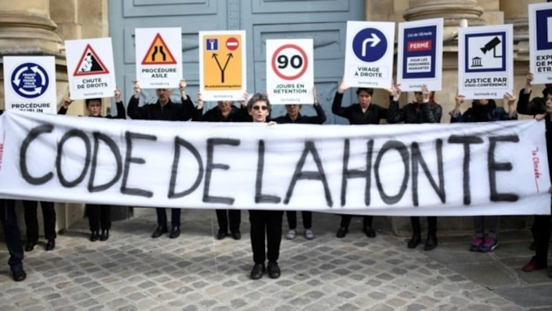 Menschen demonstrieren in Paris gegen die schärferen Asylgesetze. Auf dem Plakat steht: „Gesetz der Schande“. (Bild: AFP )