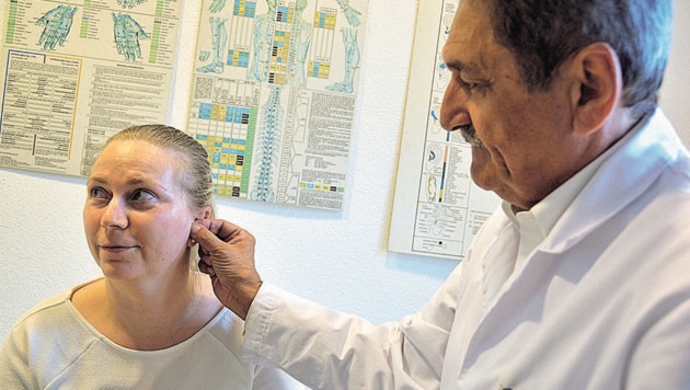 Der Linzer Laserpunkteur Dr. Michael Kesztele zeigt, welcher Punkt im Ohr massiert werden muss, um die Cortisonausschüttung anzuregen. (Bild: Johann Haginger)