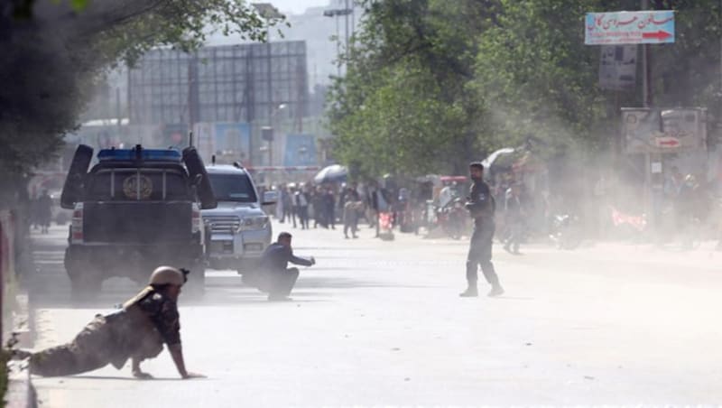 Sicherheitskräfte und Zivilisten am Ort der Selbstmordanschläge in Kabul (Bild: AP)