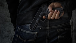 Die Räuber hatten beim Überfall vor zehn Jahren in Ried im Innkreis eine Pistole benutzt. (Bild: stock.adobe.com, krone.at-Grafik)