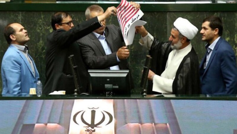 Hardliner im iranischen Parlament verbrannten am Mittwoch eine US-Flagge sowie eine Kopie des Abkommens. (Bild: AFP)