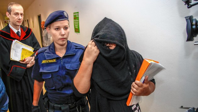 Die Angeklagte verhüllte beim Gang durch das Landesgericht Salzburg ihr Gesicht (Bild: Markus Tschepp)