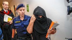 Die Angeklagte verhüllte beim Gang durch das Landesgericht Salzburg ihr Gesicht (Bild: Markus Tschepp)