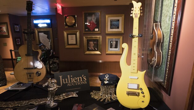 Prince‘ gelbe „Cloud“-Gitarre (rechts) kam ebenso unter den Hammer wie die „Hofner Club 40“ von Beatle George Harrison (links). (Bild: AFP)