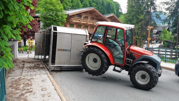 Der rote Traktor mit dem umgestürzten Anhänger. (Bild: FF Saalbach-Hinterglemm)