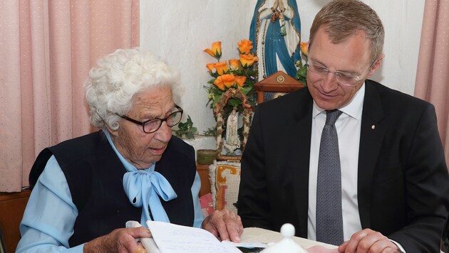 LH Thomas Stelzer blättert mit Hilde Kastner (95) in ihrem Gästebuch. (Bild: Land OÖ/Kraml)