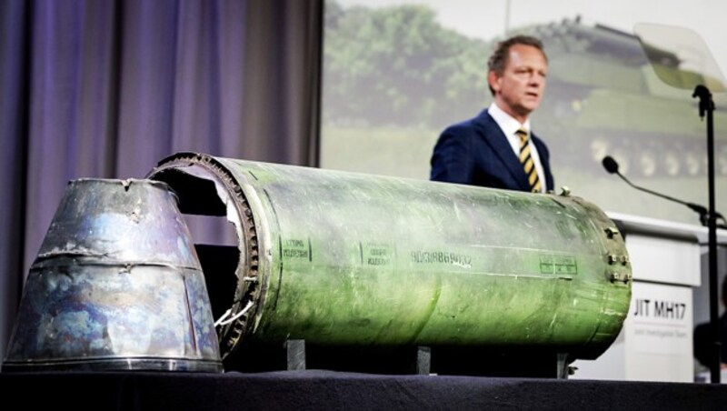 Chefermittler Fred Westerbeke bei der Präsentation des Ermittlungsberichts. Im Vordergrund sind Teile jener Buk-Abwehrrakete zu sehen, die die Malaysia-Airlines-Maschine zum Absturz gebracht hat. (Bild: APA/AFP/ANP/Robin van Lonkhuijsen)