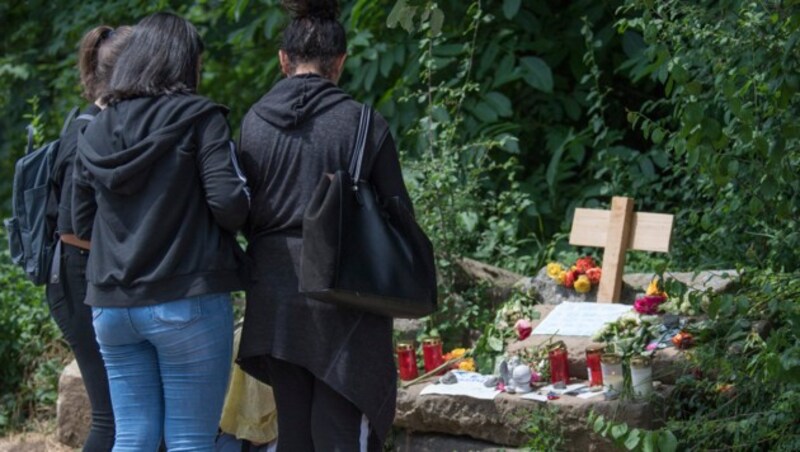 Frauen legen in der Nähe des Fundortes von Susanna F. Blumen nieder. (Bild: AFP)