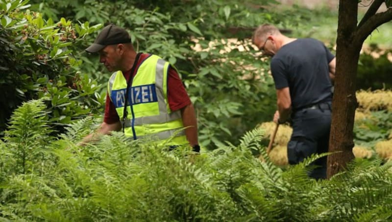 Polizisten durchsuchen nach dem tödlichen Messerangriff in Viersen ein Gebüsch. (Bild: APA/dpa/David Young)