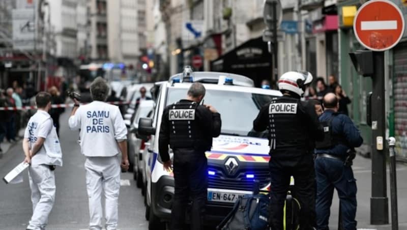 Police officer and medical emergency staff stand on a street near the site of an ongoing police operation on June 12, 2018 in central Paris. / AFP PHOTO / STEPHANE DE SAKUTIN (Bild: AFP or licensors)