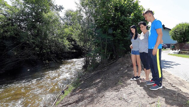 Carmen, Monika und Alexander vor dem Fluss, der ihnen das Leben binnen kurzer Zeit zur Hölle gemacht hat. (Bild: Jürgen Radspieler)